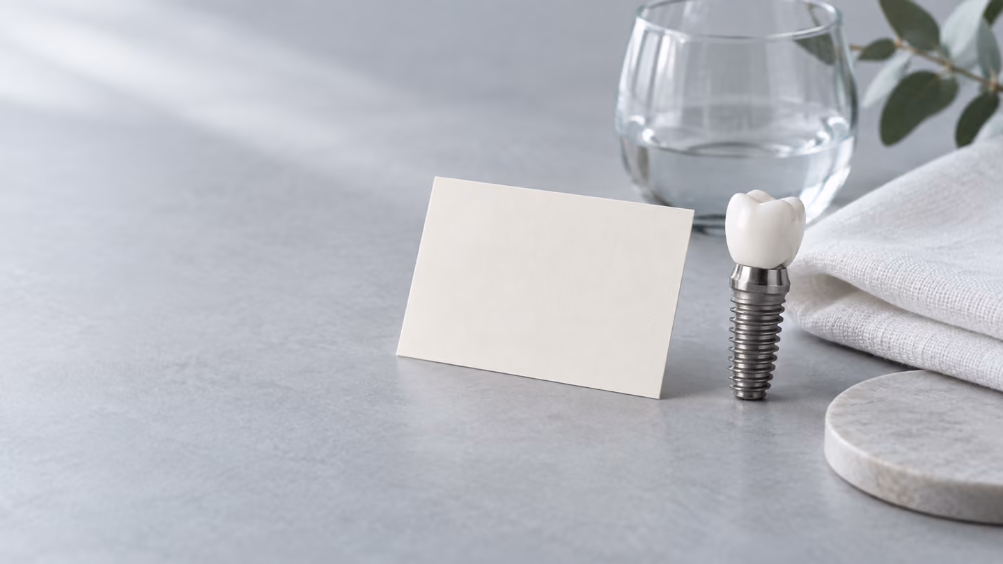 Nature morte illustrative avec un modèle d’implant dentaire, une carte vierge et un verre