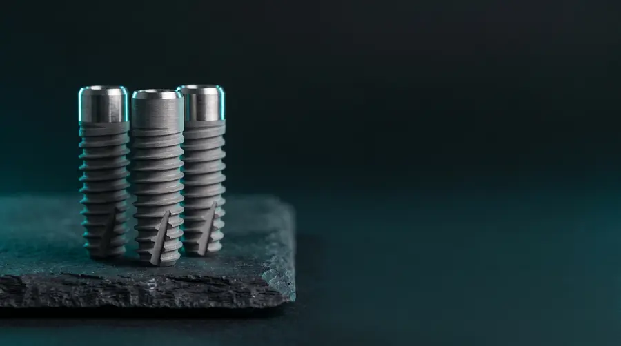 Three plain titanium implant screws on dark slate. A generated illustration of the material, not a photograph of any manufacturer's device.